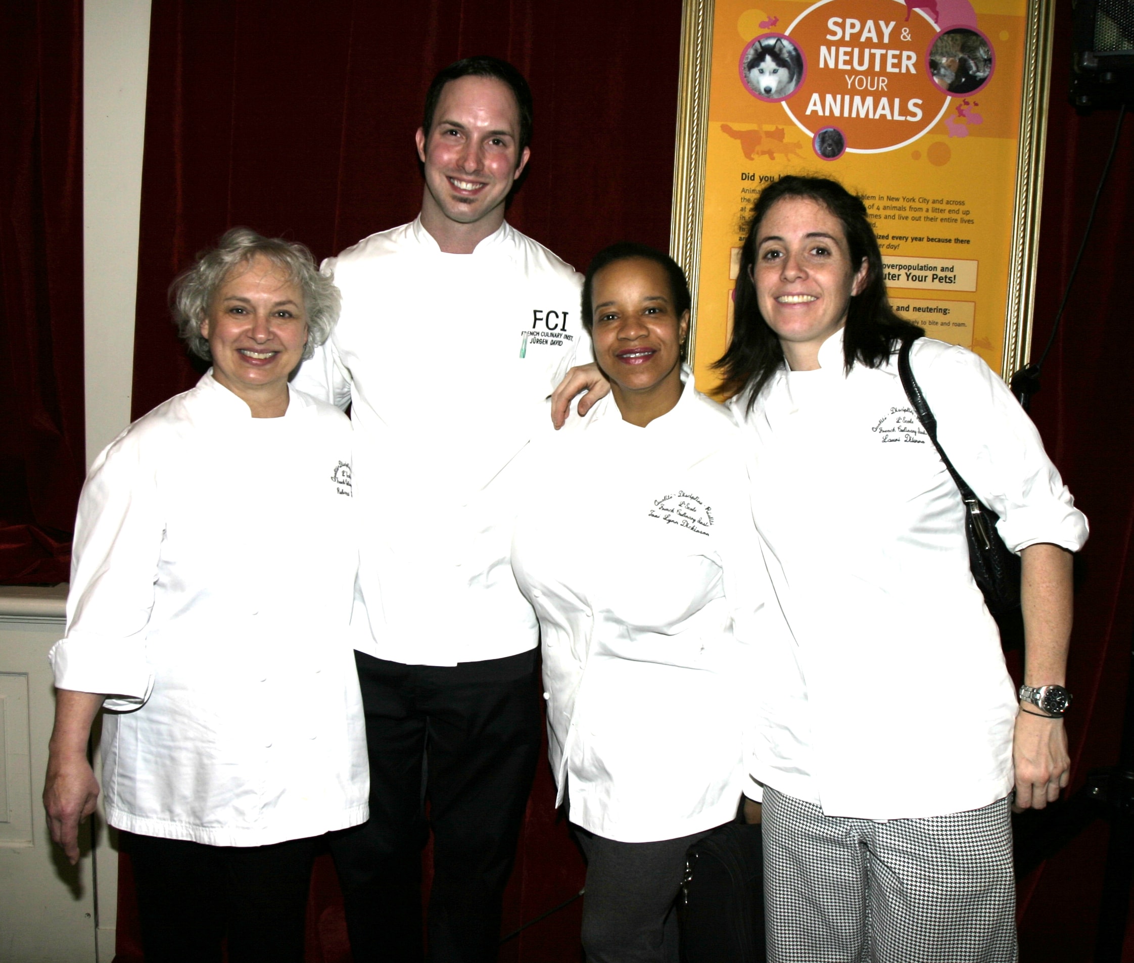 Four culinary team members in white chef coats at the Gingerbread Homes for Animals event