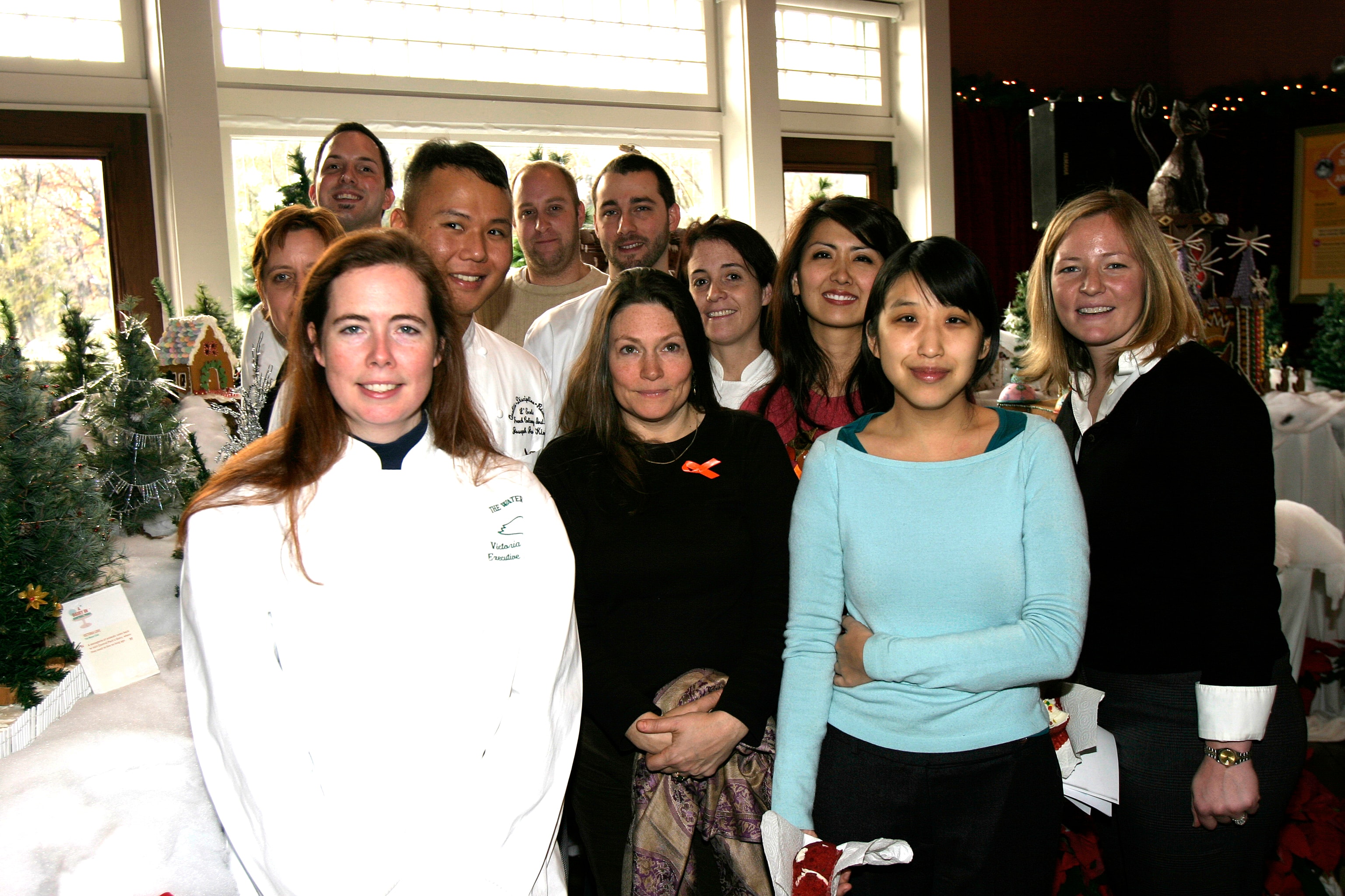 Guests and organizers smiling together at the Gingerbread Homes for Animals event